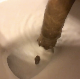 A woman takes a shit while sitting on a toilet. Camera is focused more on the end results of the poop falling into the toilet rather than the woman. Presented in 720P HD. Over 2 minutes.